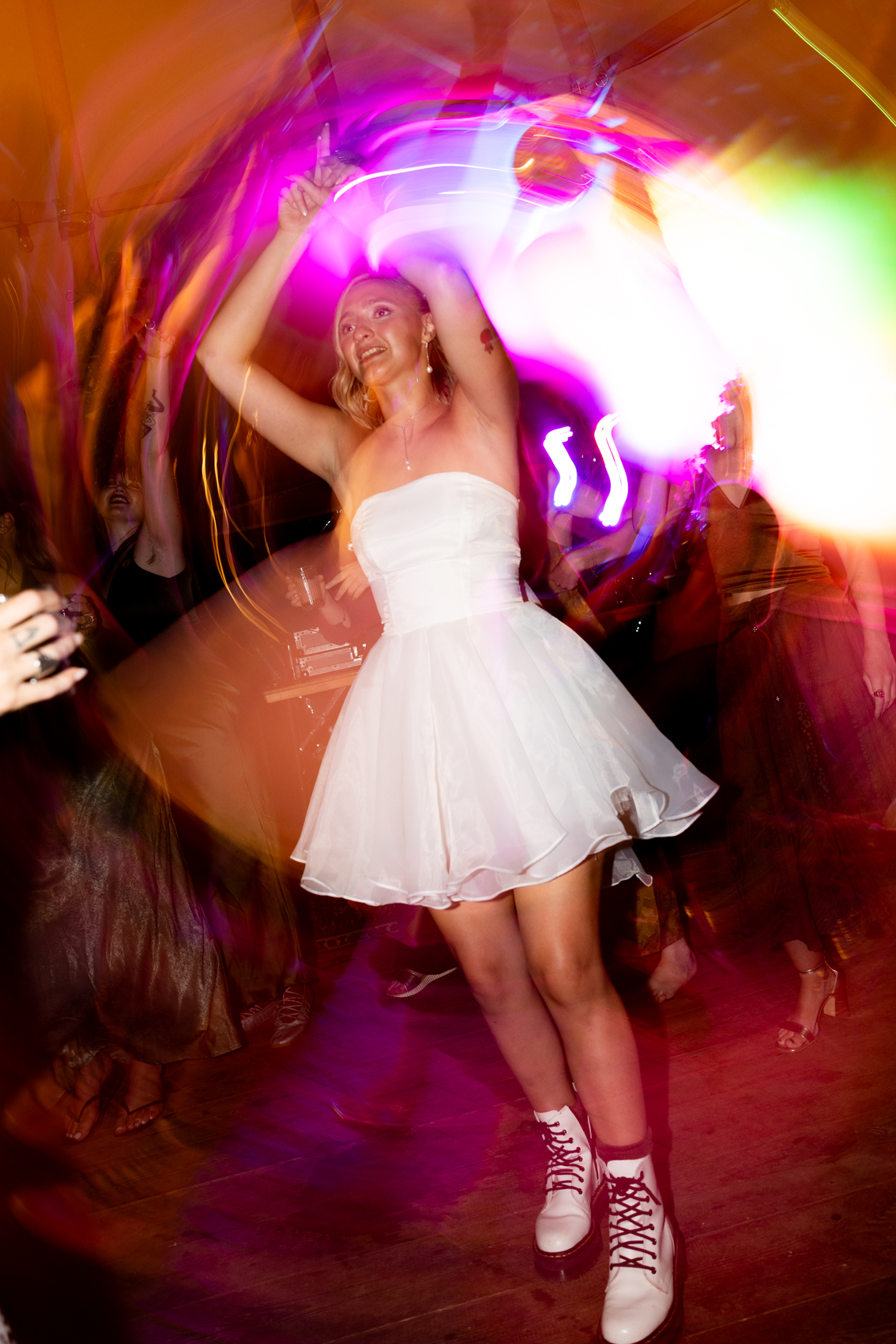 Bride dancing under neon lights on the dance floor at a wedding reception